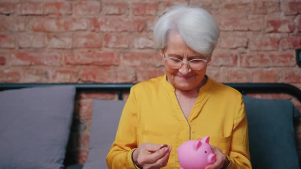 Satisfied Elderly Senior Grandmother Woman Saving Money in His Piggy Bank