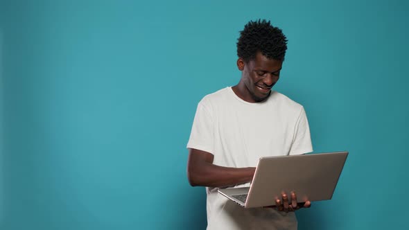 African American Man Using Laptop for Entertainment