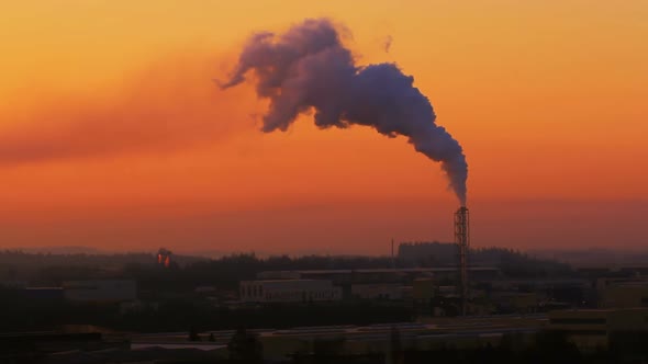Sunrise silhouette of smoking factory