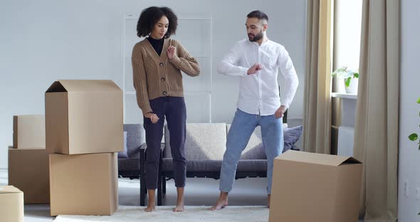 Cardboard Boxes Stand in Living Room Young Adult Couple Owners Buyers Dance Together Make Identical