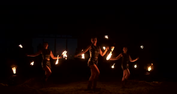 A Group of Professional Artists with Fire Show the Show Juggling and Dancing with Fire in Slow