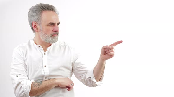 Gray Haired Man Pointing with His Finger to a Direction to His Left Medium Close Up Shot White