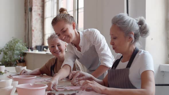 Craftswoman Helping Students in Art Studio