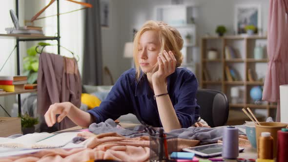 Young Woman Designer Tired While Working on a New Dress