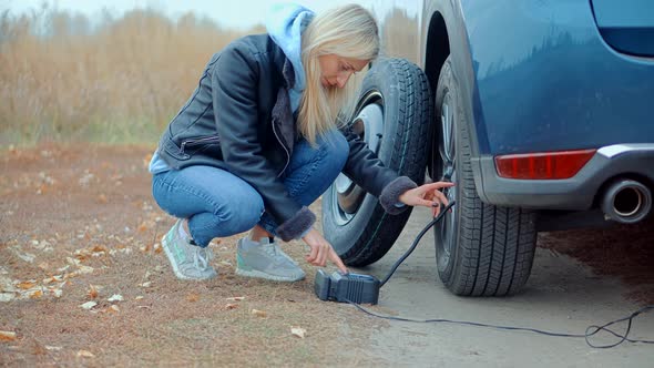 Checking Tire Pressure. Pumping Air Into Auto Wheel. Electric Pump Inflates Pressure Gauge For Car.