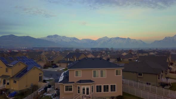 Raising above a suburban neighborhood to reveal a communter train passing through the valley with mo