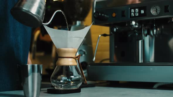 Barista making the aroma of  Filter coffee for female costumer.