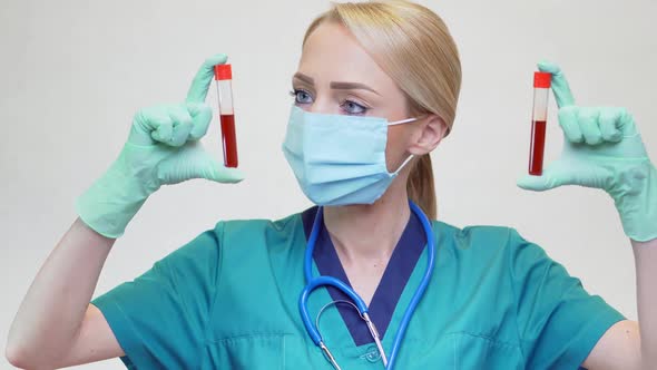 Medical Doctor Nurse Woman Wearing Protective Mask and Latex Gloves - Holding Blood Test Tube