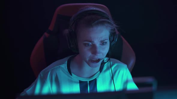 HANDHELD Portrait of an Emotional Female Gamer in Headphones Plays a Video Game Cyber Sportsman