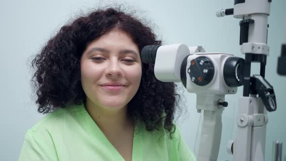 Portrait of Confident Positive Woman Sitting at Retina Camera in Ophthalmologic Clinic Smiling