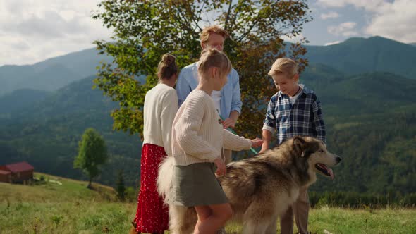 Friendly People Walking Dog on Green Hill