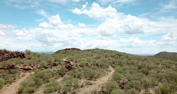 Forward moving drone shot on a mountain on a dry game farm during drought near Okahandja, Namibia.