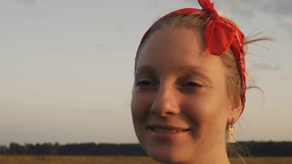 Beautiful Blonde Woman Smiling in the Rays of the Setting Sun