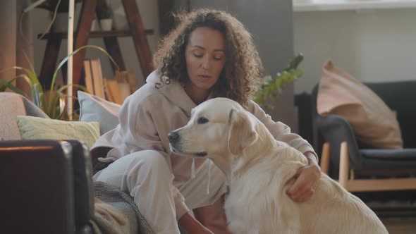 Portrait of Happy Woman with Golden Retriever at Home