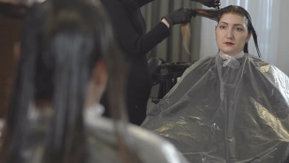 Young Woman in Beauty Salon. Hair Care. Reflection in the Mirror