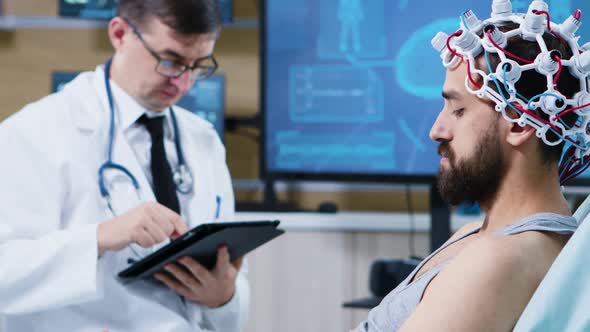 Patient Sitting on Hospital Bed and Wearing Brainwaves Scanning Headset