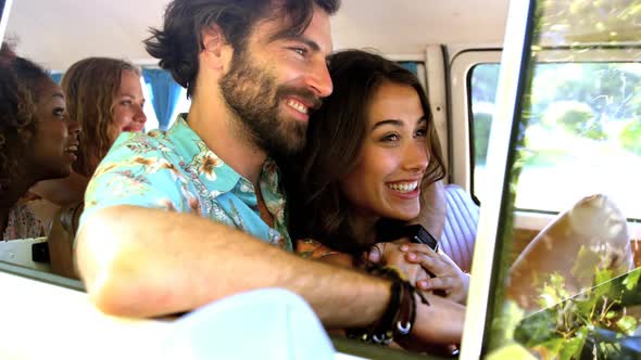 Hipster friends talking inside of a van