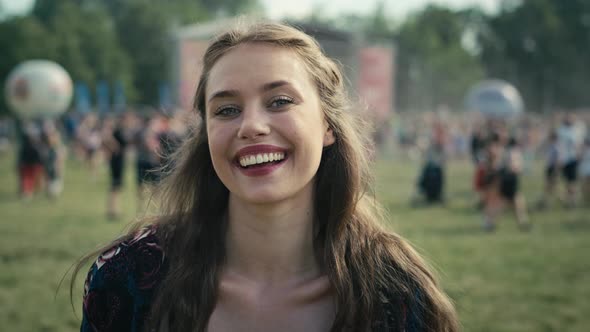 Portrait of smiling young caucasian woman at music festival. Shot with RED helium camera in 8K.