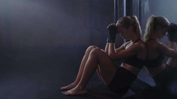 Tired Sweaty Boxer Woman is Sitting Leaned Back on the Mirror in the Boxing Gym After Hard Training