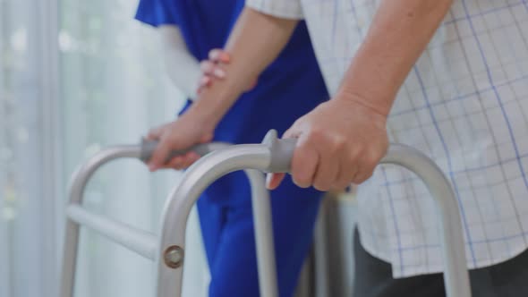 Close up a hands of Asian young woman nurse at nursing home taking care disabled elderly man.