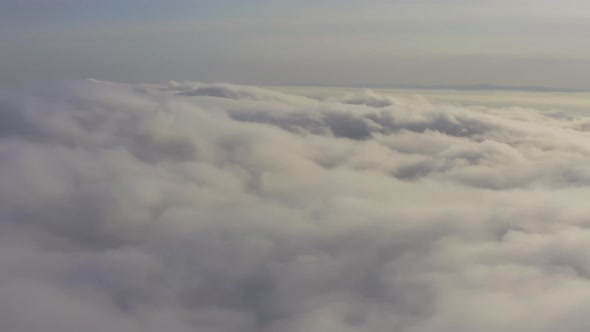 Aerial View Flying Through Cumulus Clouds at Sunset