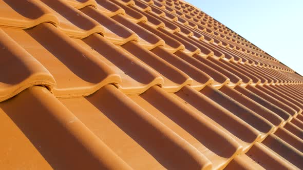 Overlapping Rows of Yellow Ceramic Roofing Tiles Covering Residential Building Roof