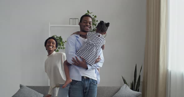 Caring Father Holds in Arms His Beloved Daughter Little Girl While Mother Dodges in Different Sides