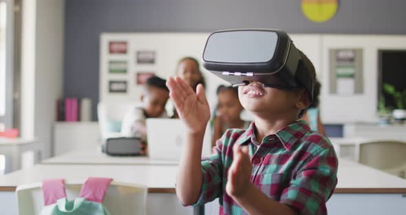 Video of happy african american boy wearing vr headset in classroom