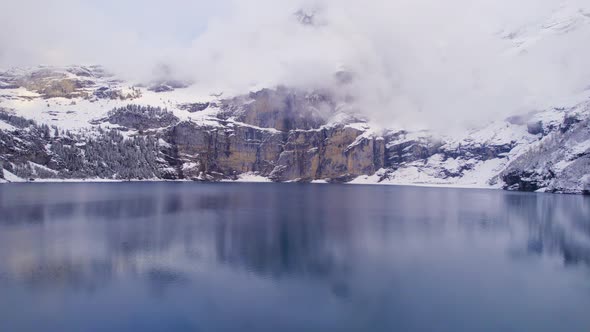 Oeschinen Lake in Switzerland Surrounded by Snow Covered Forests and Mountains