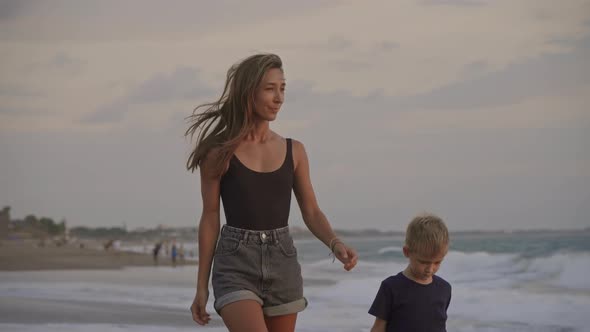 Mother and Son Strolling Along Sea Coast