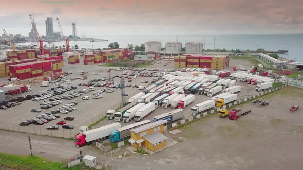 Shooting from a drone to a truck parking lot. Many trucks are parked at port,