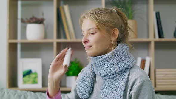 A Woman with Fever and Runny Nose Uses Nasal Spray