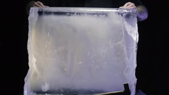 Artist is Standing Behind a Massive Ice Block Before Carving It