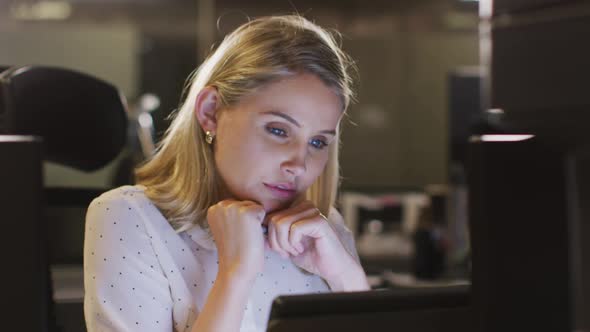 Professional businesswoman working while sitting on her desk in modern office in slow motion