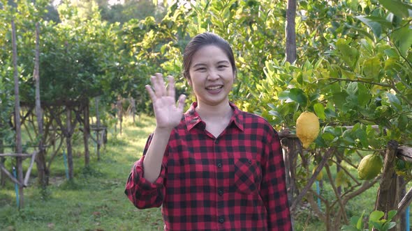 Portrait of happy cheerful young Asian farmer smiling, waving hand, greeting