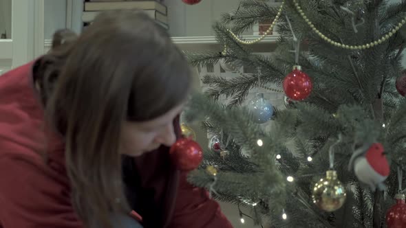 Lady Puts Gifts Under Tree. Concept of Holiday and Hearth