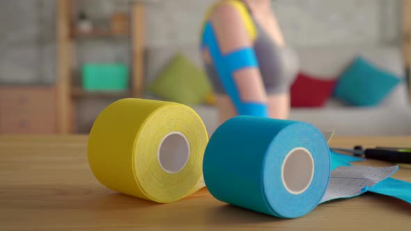 Colorful on the Table Rolls Kinesiotape Background Sports Female Athlete with a Tape on His Hand