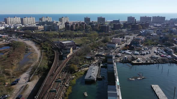 An aerial shot over Grassy Bay in Queens, NY. The camera dolly in near elevated train tracks