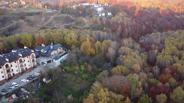 Aerial view of a drone flying over the apartment building and forest.