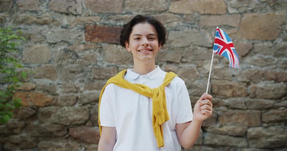 Portrait of Proud British Citizen Teenager with UK Flag Smiling Outdoors