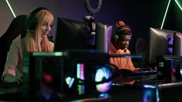 a Caucasian Girl and an AfroAAmerican Boy Playing Video Games eSport Tournament