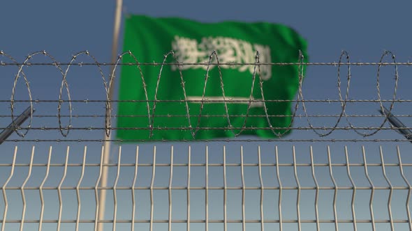 Barbed Wire Against Waving Flag of Saudi Arabia