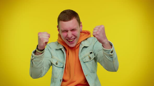 Teen Man in Denim Jacket Shouting Raising Fists in Gesture I Did It Celebrating Success Winning