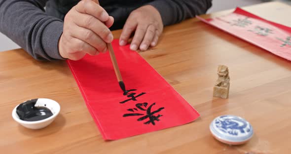 Man write chinese calligraphy for lunar new year