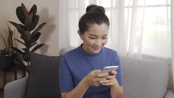 Asian woman on using a smartphone with AI voice command for a chat with customer