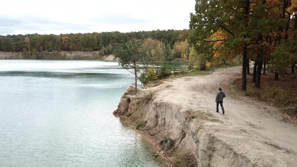 Man Walking Along Lake