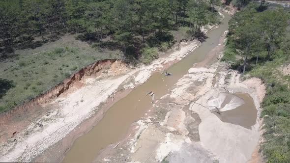 Qualified Miners Work on Narrow Muddy River and Extract Grit