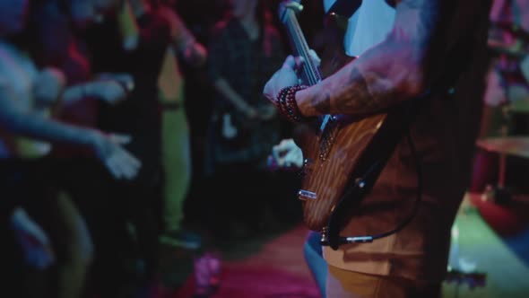 Scene of Concert in Small Club with Closeup on Guitar While Musician Jamming Solo