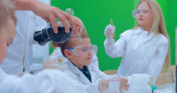 Teacher and Students Doing Science Experiment in School Classroom