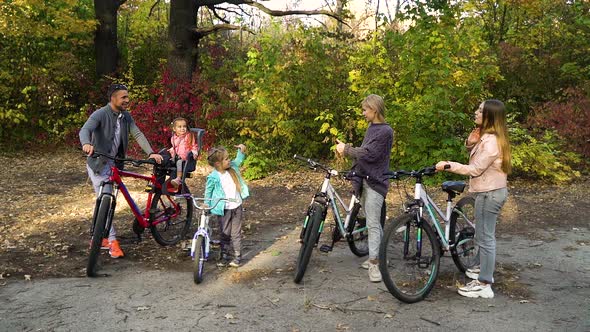 Happy Family Showing Thumbs Up After Cycle Ride in Park